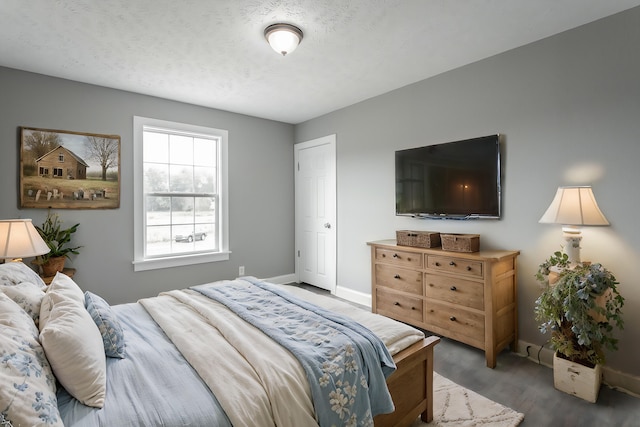 bedroom with a textured ceiling and dark hardwood / wood-style floors