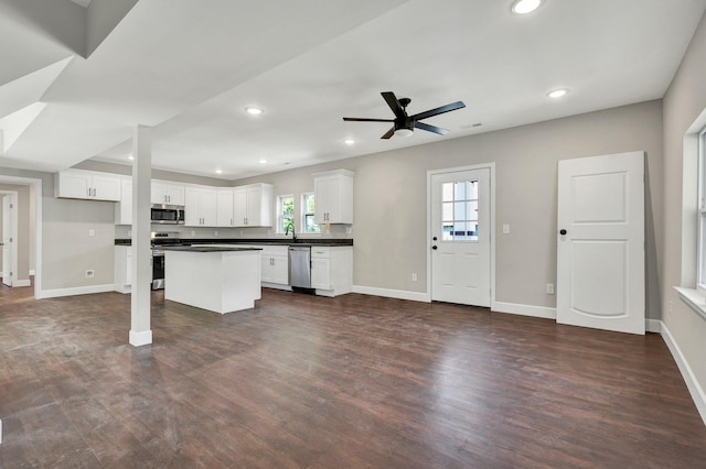 kitchen with dark hardwood / wood-style flooring, white cabinets, ceiling fan, and stainless steel appliances