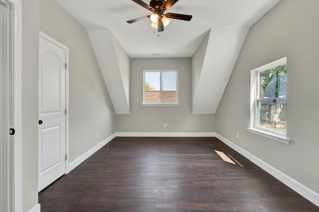 additional living space with vaulted ceiling, dark hardwood / wood-style flooring, ceiling fan, and plenty of natural light