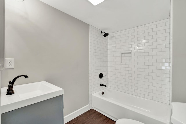 full bathroom with wood-type flooring, tiled shower / bath combo, vanity, and toilet