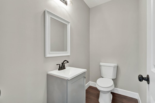 bathroom featuring wood-type flooring, vanity, and toilet