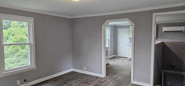 unfurnished room featuring crown molding, dark hardwood / wood-style flooring, and a wall unit AC