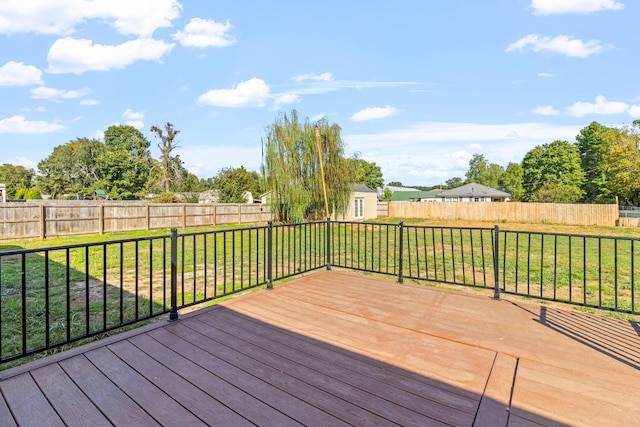 wooden terrace with a yard and a storage unit