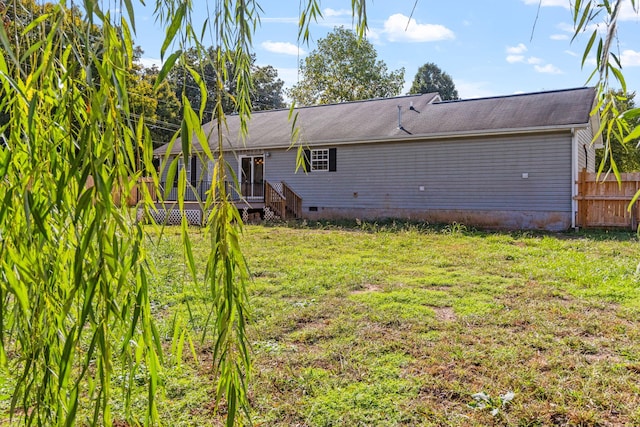 back of house featuring a yard and a deck