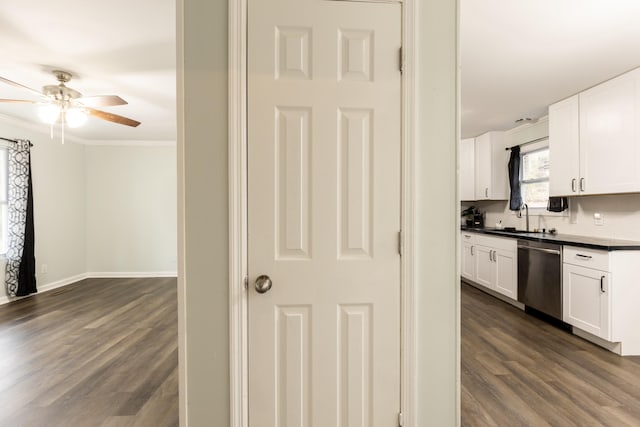 kitchen featuring dishwasher, dark hardwood / wood-style floors, ornamental molding, sink, and white cabinetry