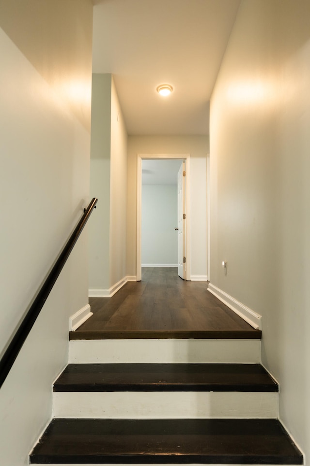 staircase featuring baseboards and wood finished floors