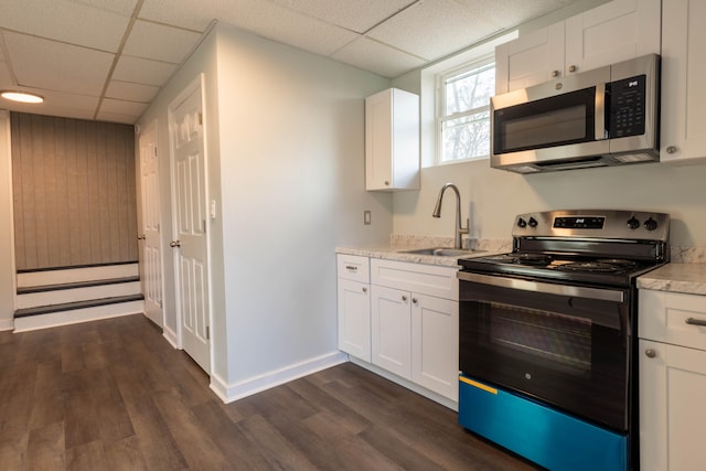 kitchen with white cabinets, a paneled ceiling, dark hardwood / wood-style floors, sink, and stainless steel appliances