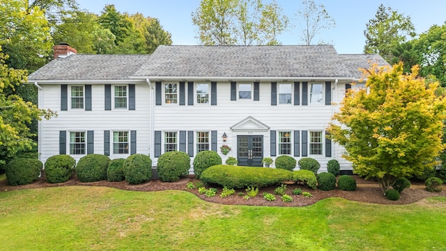 colonial home featuring a front lawn