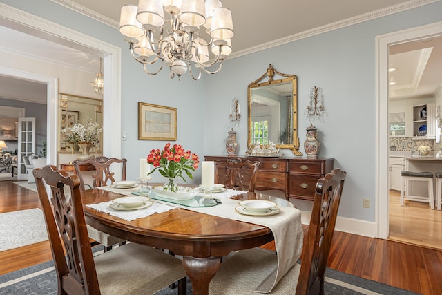 dining area featuring ornamental molding, a chandelier, and hardwood / wood-style flooring