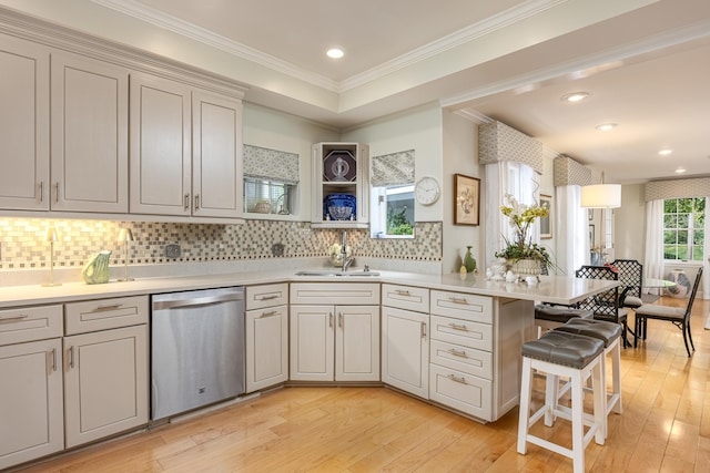 kitchen featuring crown molding, light hardwood / wood-style floors, dishwasher, and sink