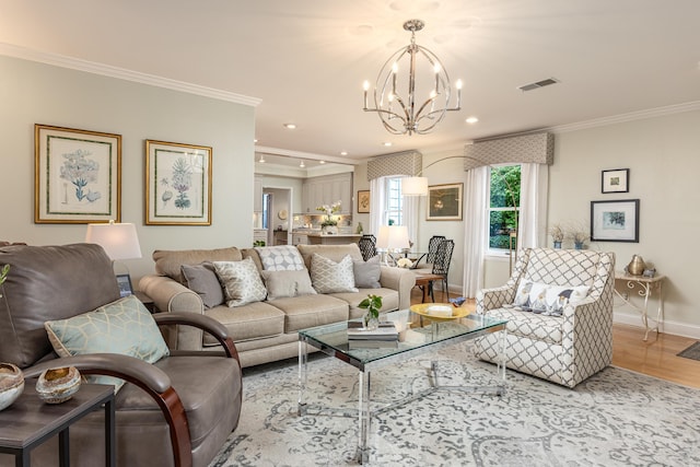 living room featuring a notable chandelier, hardwood / wood-style floors, and crown molding