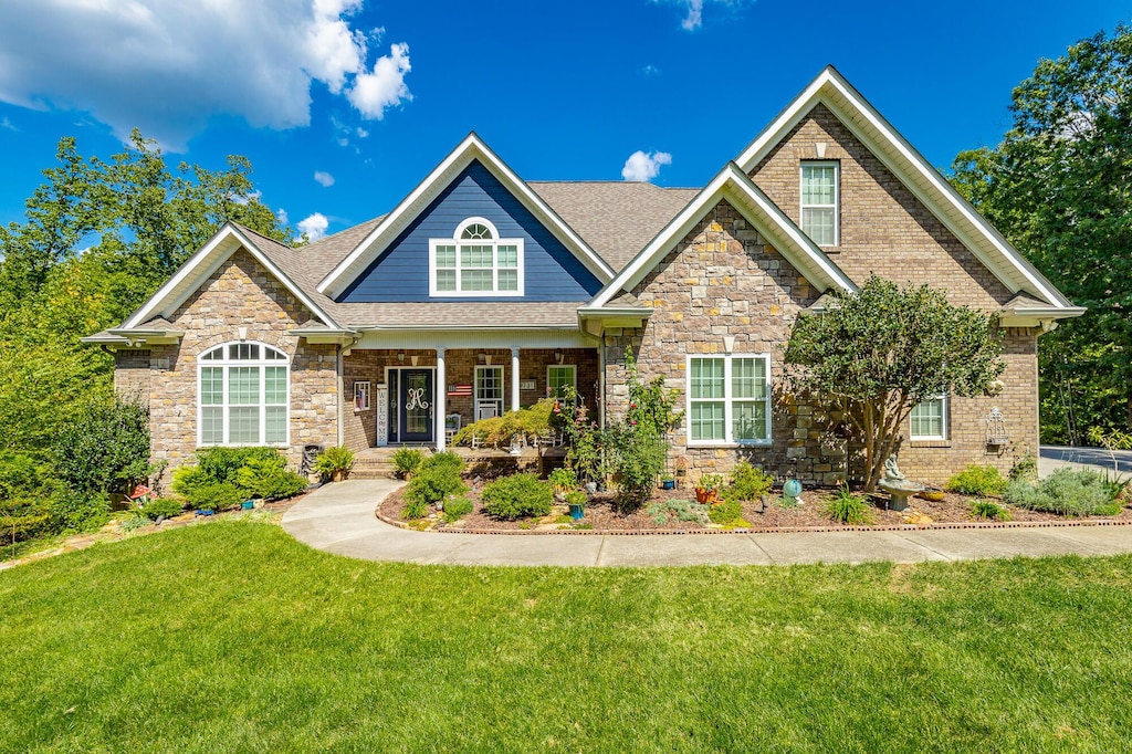9731 Deer Ridge Dr, Ooltewah, TN 37363 - craftsman inspired home with a porch, stone siding, a front yard, and a shingled roof