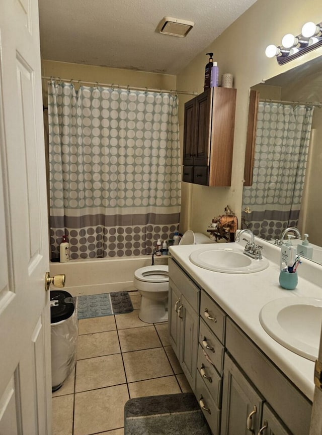 full bathroom with tile patterned flooring, a textured ceiling, toilet, vanity, and shower / tub combo