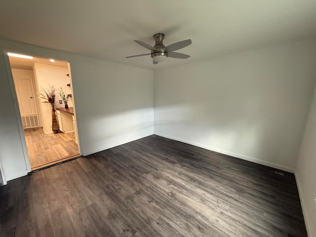 spare room with ceiling fan and dark wood-type flooring