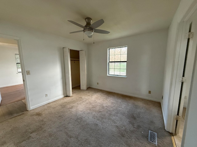 unfurnished bedroom with light colored carpet and ceiling fan