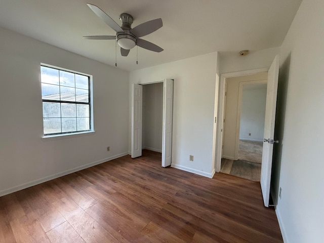 unfurnished bedroom featuring ceiling fan and dark hardwood / wood-style flooring