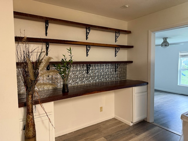 bar with ceiling fan and dark wood-type flooring