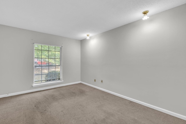 carpeted empty room featuring a textured ceiling