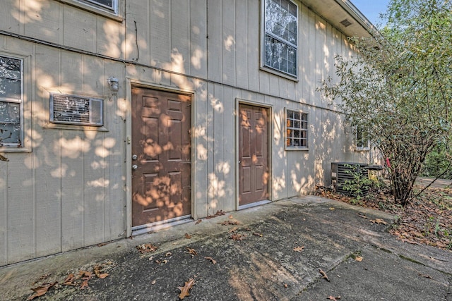 doorway to property with cooling unit and a patio area