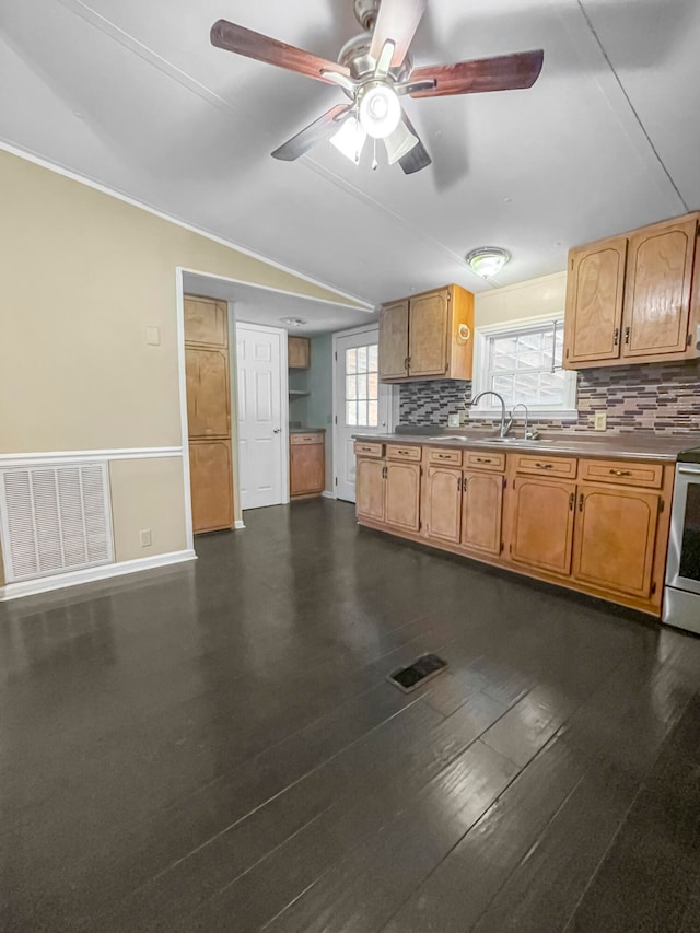 kitchen with ceiling fan, sink, backsplash, dark wood-type flooring, and stainless steel stove