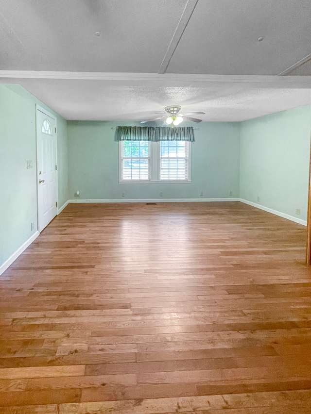 spare room featuring a textured ceiling, light hardwood / wood-style floors, and ceiling fan