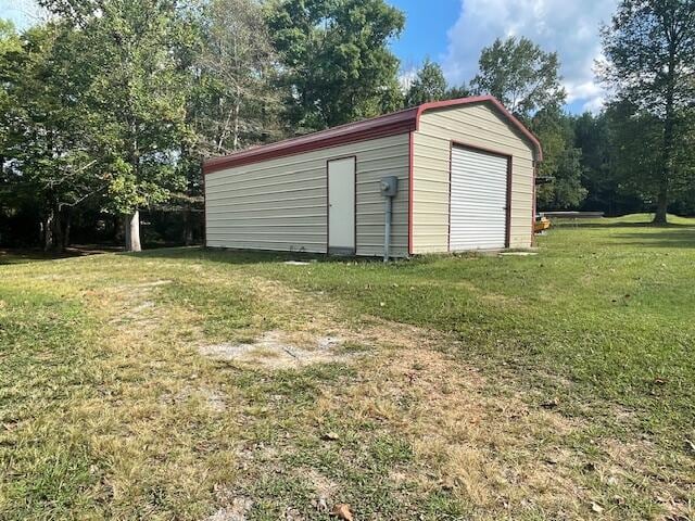 view of outdoor structure with a yard and a garage