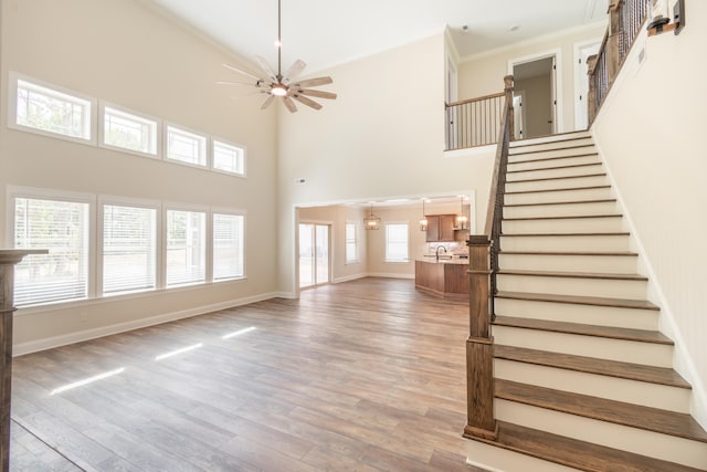 unfurnished living room with a towering ceiling, plenty of natural light, and hardwood / wood-style floors