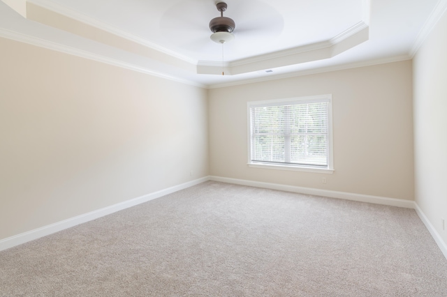 unfurnished room featuring ceiling fan, ornamental molding, a tray ceiling, and carpet floors