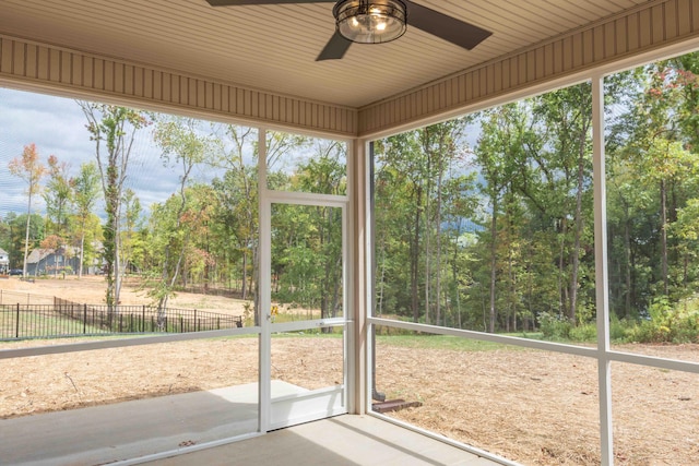 unfurnished sunroom with ceiling fan