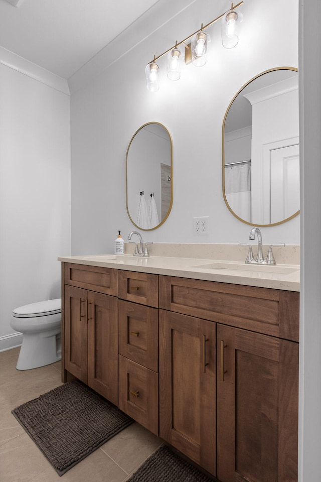 bathroom with tile patterned flooring, vanity, crown molding, and toilet