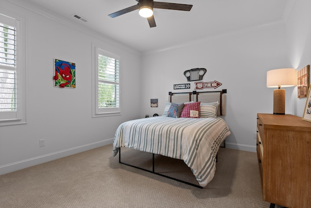 carpeted bedroom featuring multiple windows, ceiling fan, and crown molding