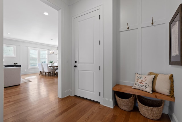 mudroom featuring an inviting chandelier and light wood-type flooring