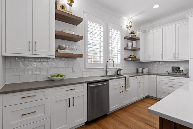 kitchen with tasteful backsplash, dishwasher, light hardwood / wood-style flooring, and white cabinets