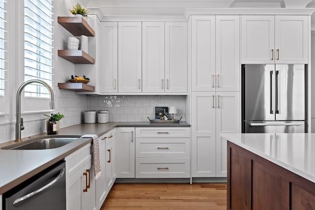 kitchen with white cabinetry, sink, light wood-type flooring, and appliances with stainless steel finishes