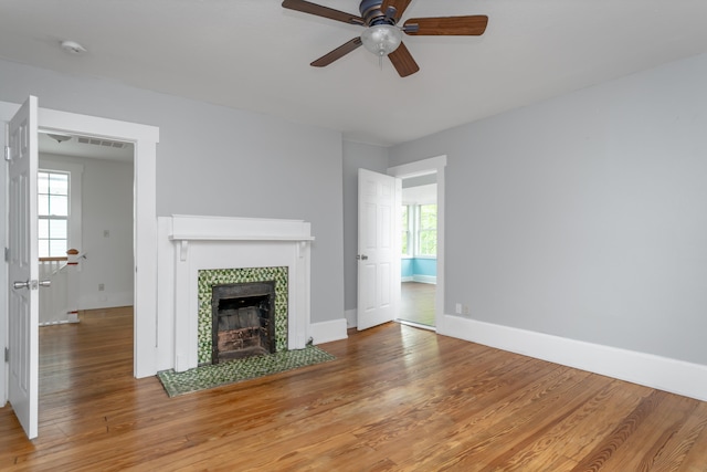 unfurnished living room featuring ceiling fan, a fireplace, and hardwood / wood-style floors