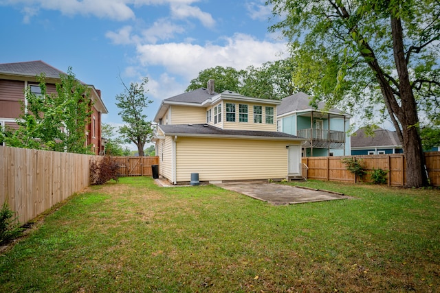 rear view of property featuring a lawn and a patio