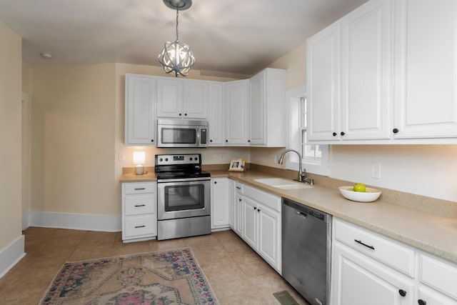 kitchen featuring pendant lighting, sink, a chandelier, white cabinetry, and stainless steel appliances