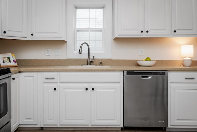 kitchen with appliances with stainless steel finishes, white cabinetry, and sink