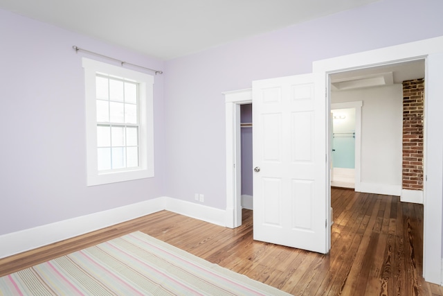 unfurnished bedroom with a closet and dark wood-type flooring