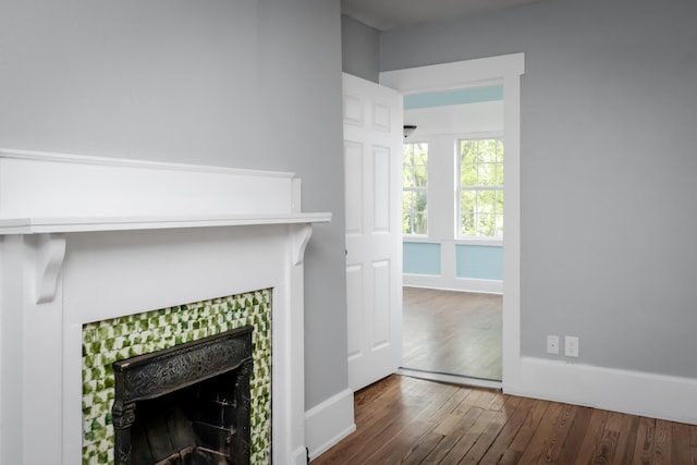 interior details with a tile fireplace and wood-type flooring