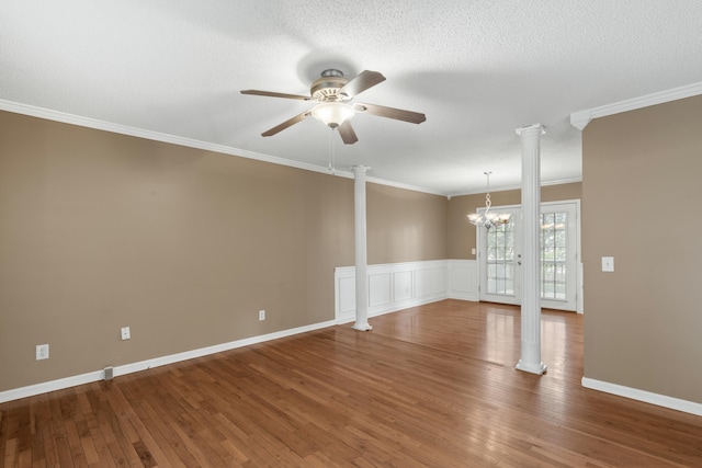 unfurnished room featuring a textured ceiling, hardwood / wood-style flooring, ceiling fan with notable chandelier, decorative columns, and crown molding