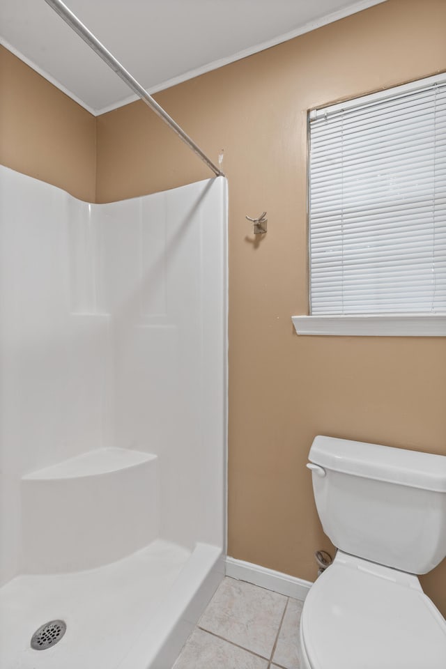 bathroom featuring a shower, toilet, and tile patterned floors