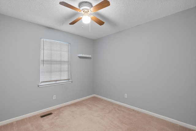 carpeted empty room featuring ceiling fan and a textured ceiling