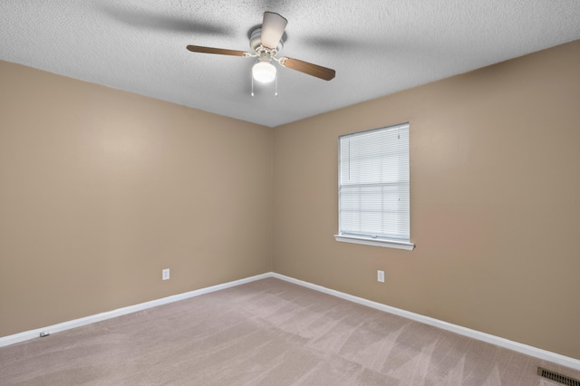 empty room featuring a textured ceiling, light carpet, and ceiling fan