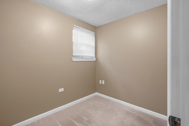 unfurnished room with a textured ceiling and carpet