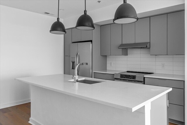 kitchen with hanging light fixtures, a center island with sink, gray cabinetry, and stainless steel appliances