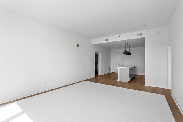 unfurnished room featuring dark hardwood / wood-style floors and sink