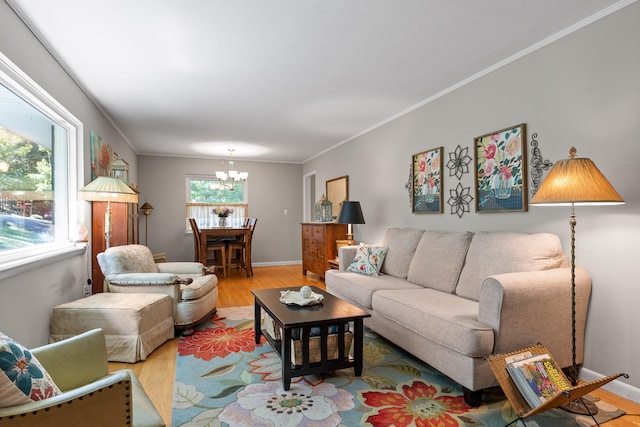 living room with ornamental molding, light hardwood / wood-style flooring, and a chandelier