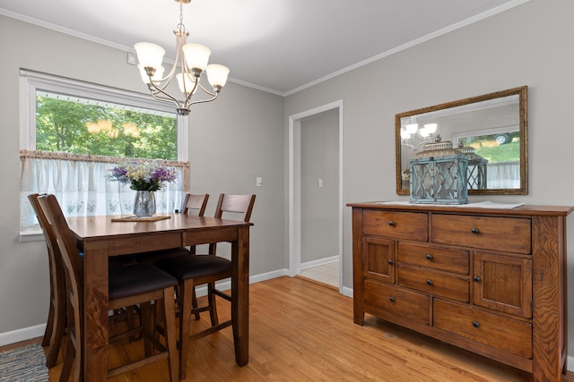 dining room with ornamental molding, light hardwood / wood-style floors, and an inviting chandelier