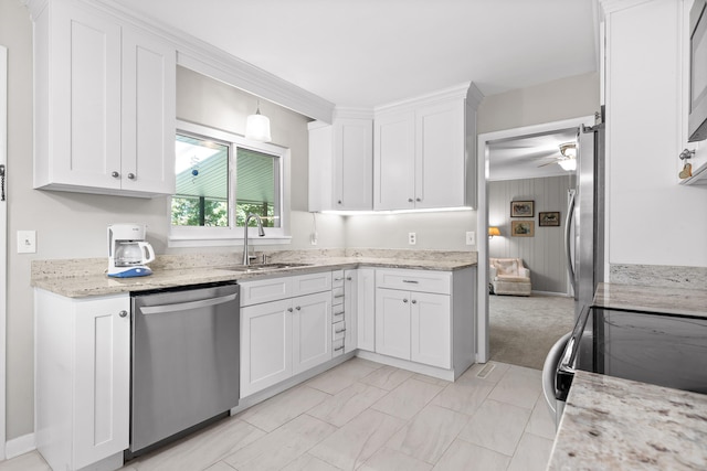 kitchen with pendant lighting, light stone counters, sink, white cabinetry, and appliances with stainless steel finishes